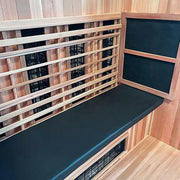 A modern sauna interior features the Finnmark Sauna Cushion for FD-3 in marine grade vinyl on the bench with black infrared heating panels, all set against light wood walls and floors for a sleek, inviting look.
