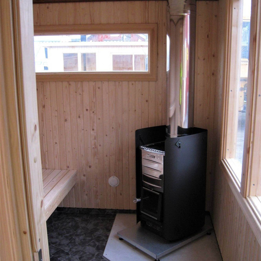 A small wooden sauna room with a bench, window, and light wood paneling features the Harvia M3 Wood-Burning Stove Kit (includes stove, protective bedding, sheath, chimney kit, and stones) from Harvia for a cozy atmosphere.