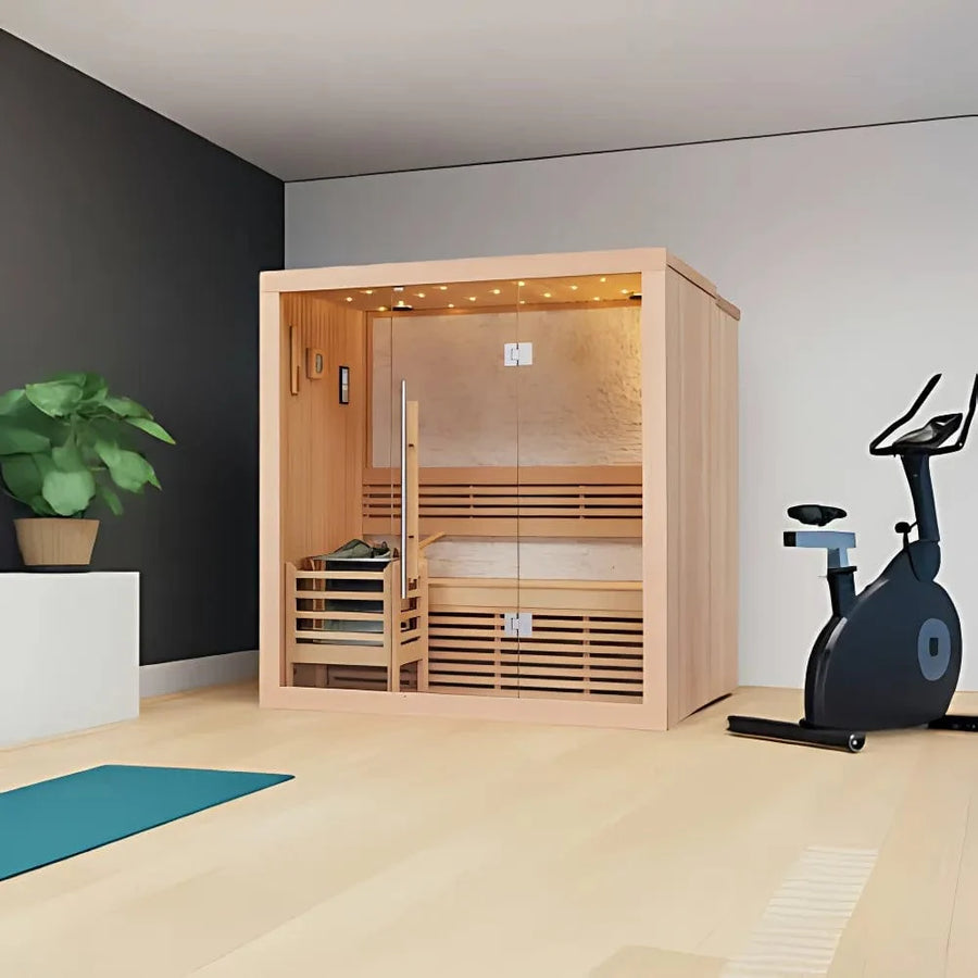 A modern home gym with a stationary bike, teal yoga mat, potted plant, and the SunRay Westlake 3 Person Indoor Traditional Sauna 300LX by SunRay, featuring glass doors and warm lighting on a light wood floor.