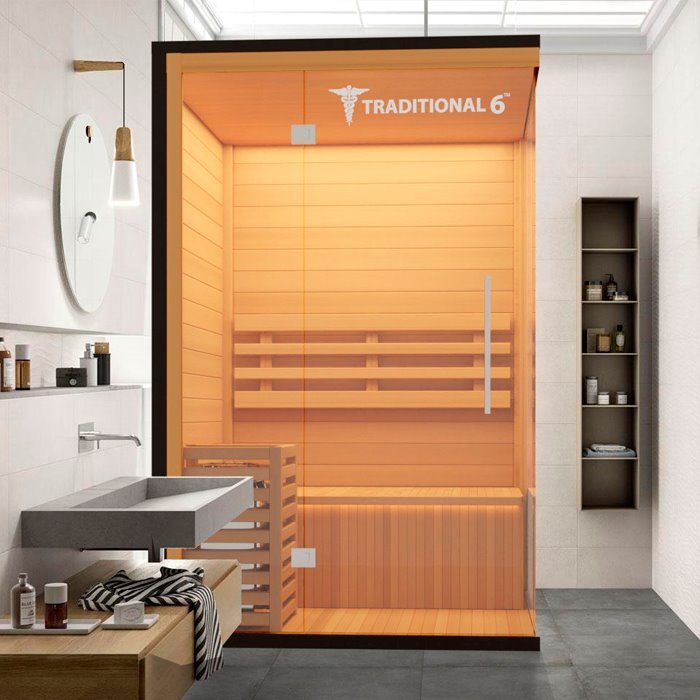 Traditional 6 Medical Sauna (2 Person) in a bathroom, featuring hemlock wood construction, internal benches, an LED control panel, and built-in speaker system for a modern sauna experience.