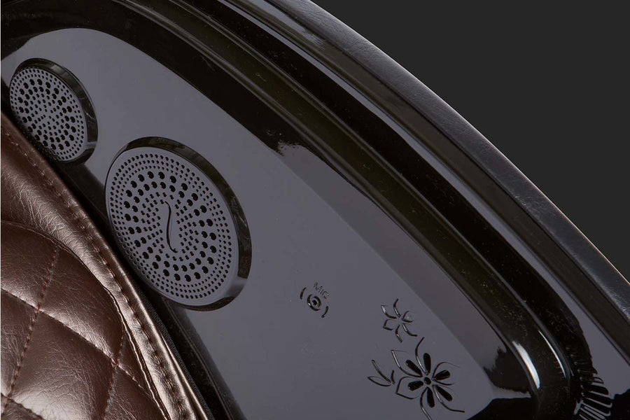 Close-up of the Kyota Kokoro M888 Massage Chair's Bluetooth speaker on a leather surface, highlighting its premium materials and advanced features.